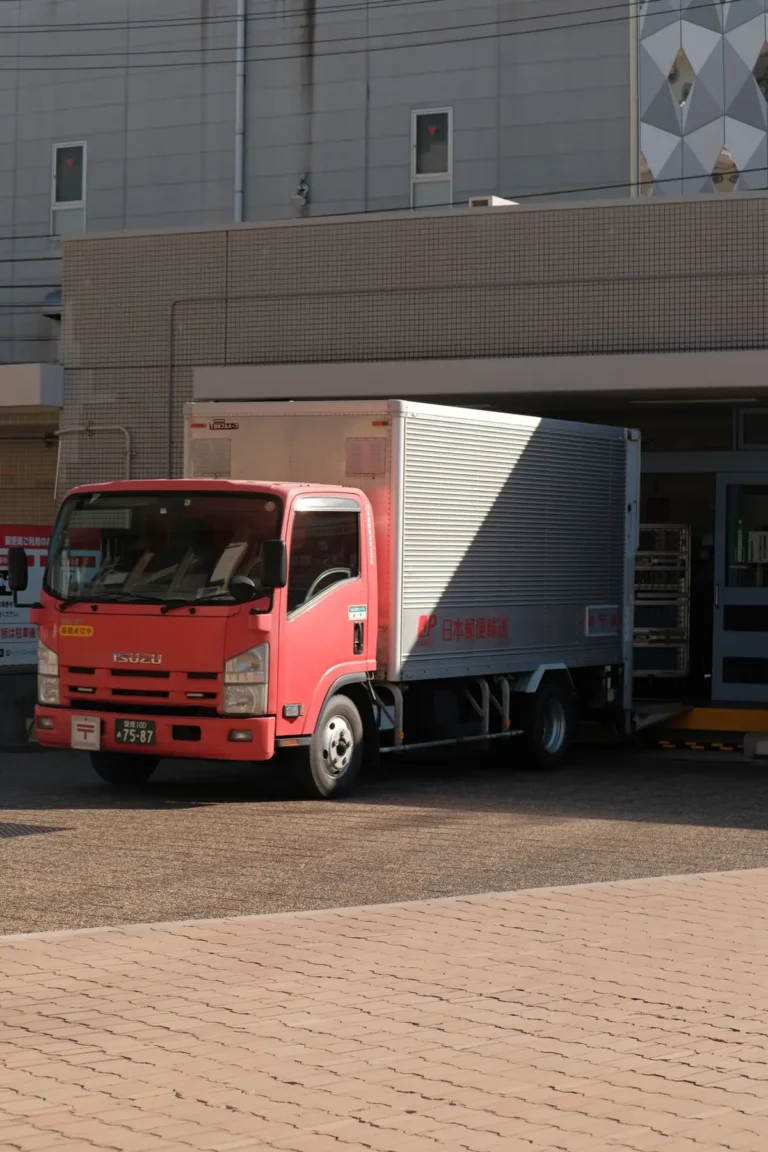 Camion de carga estacionado frente a una nave industrial