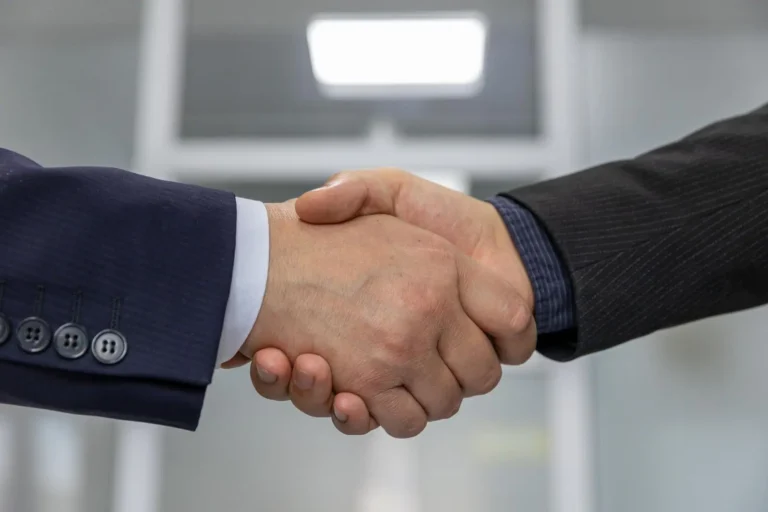 Dos ejecutivos dandose la mano para sellar un acuerdo de negocios
