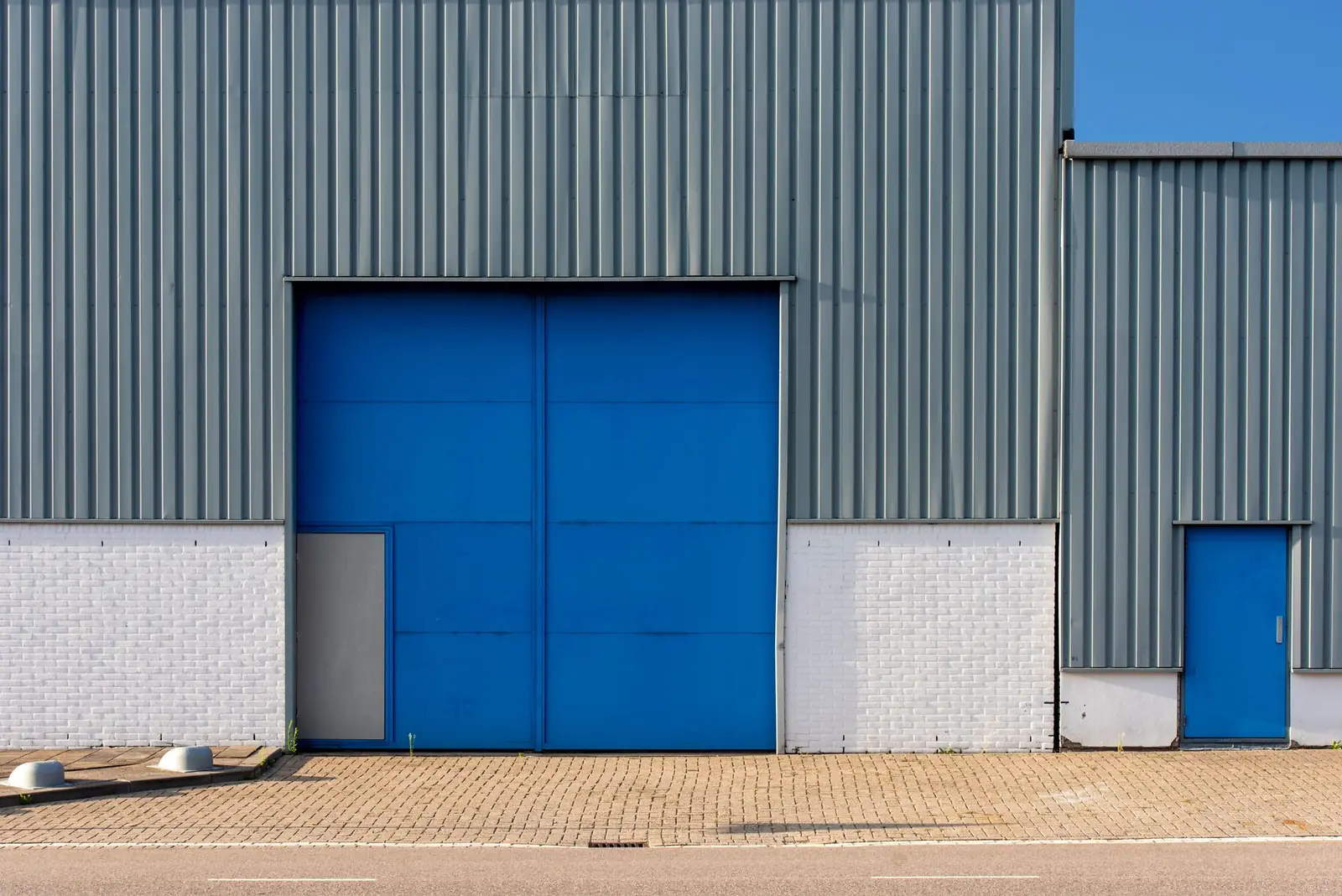 Fachada moderna de nave industrial con puerta de acceso