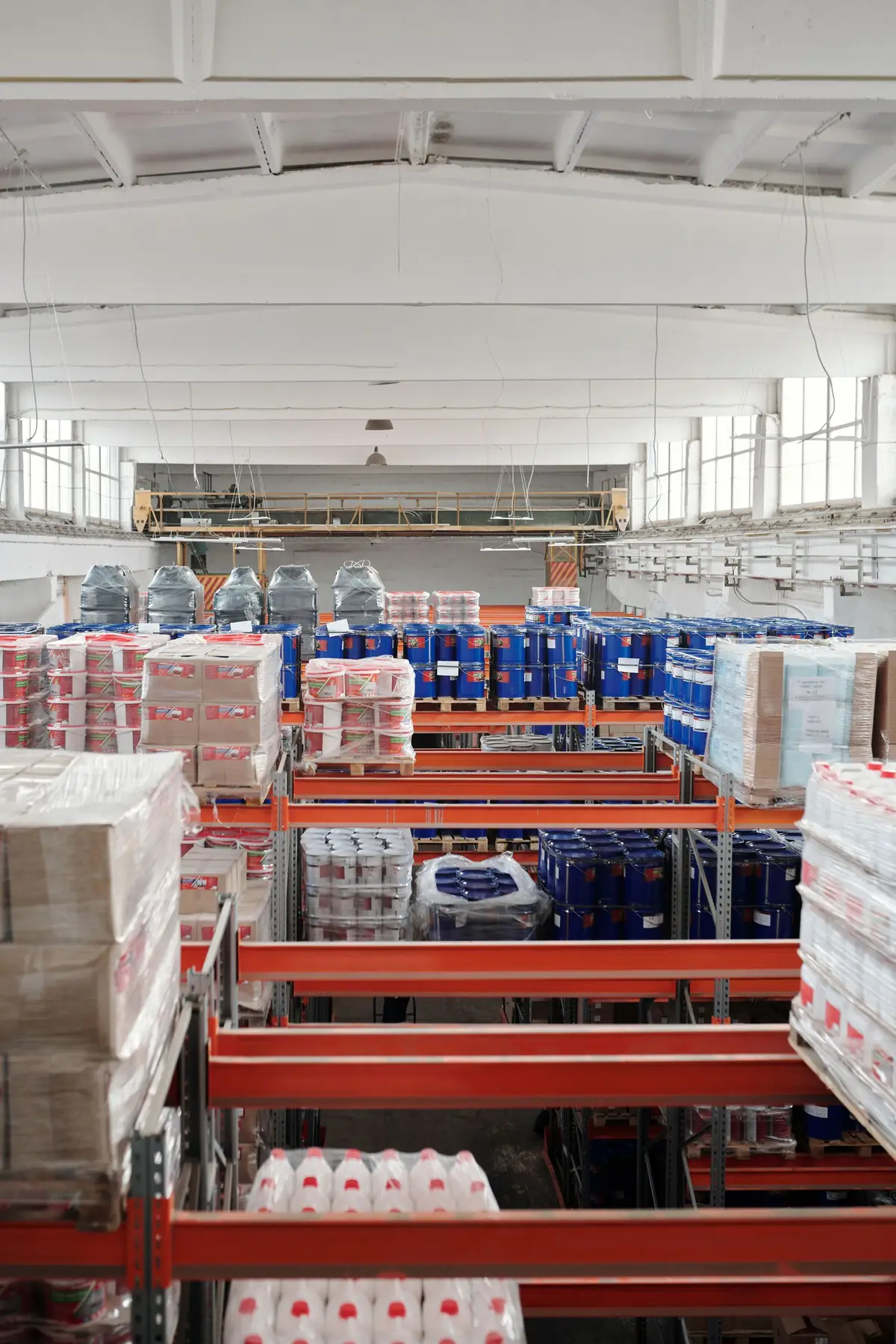 Interior de bodega industrial con inventario paletizado en anaqueles