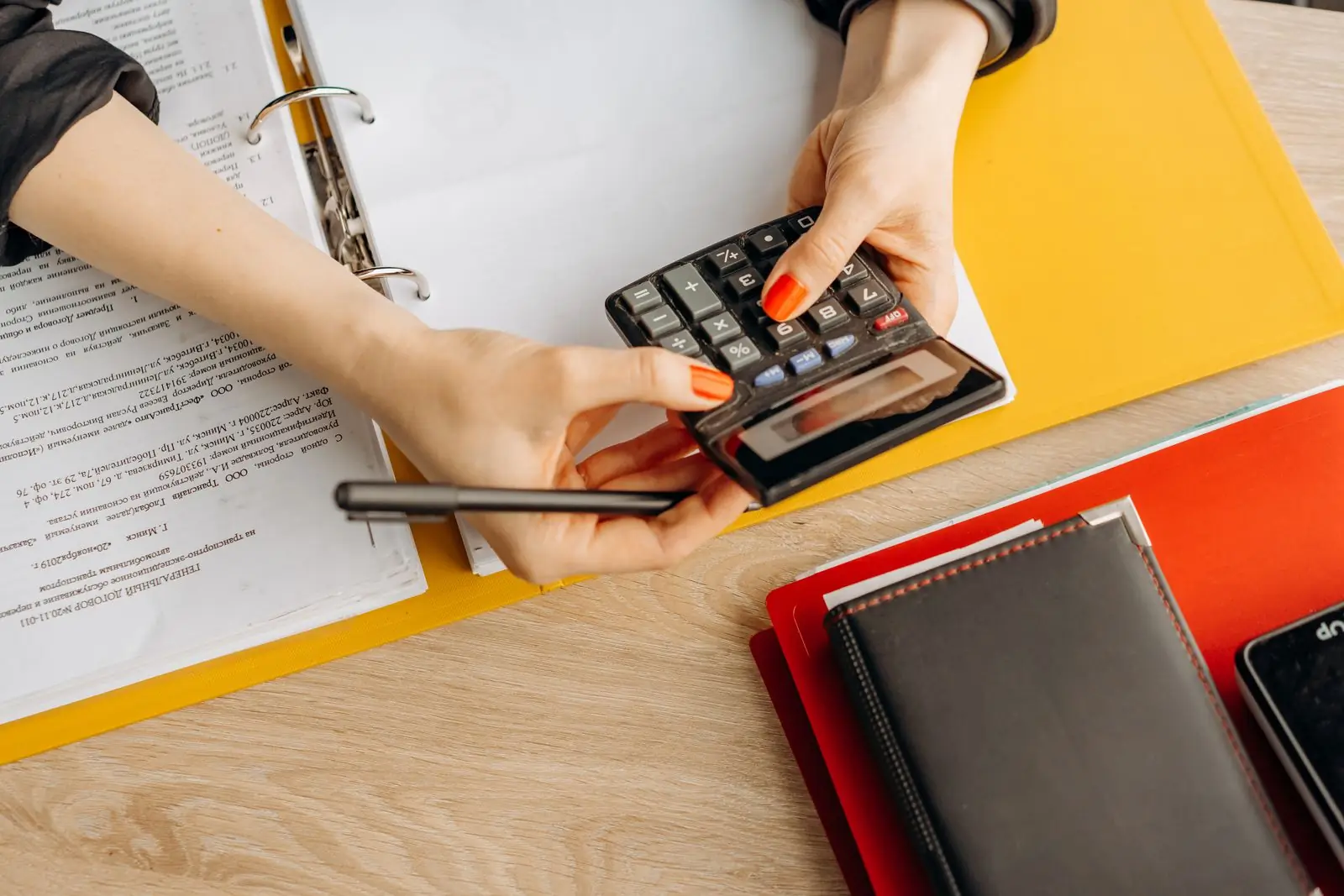 Persona haciendo cálculos financieros con calculadora junto a documentos de crédito