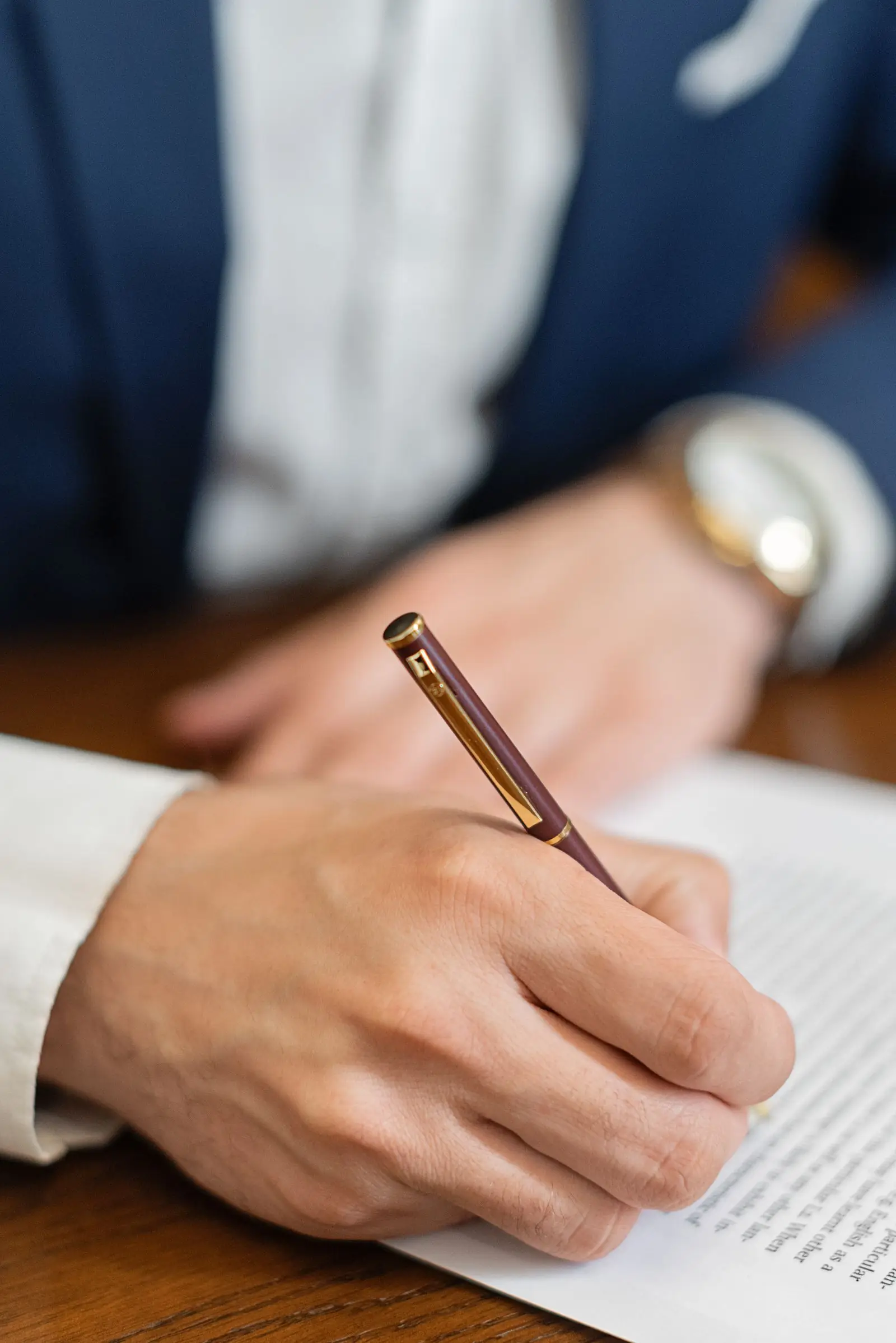Primer plano de una mano firmando un documento de contrato financiero