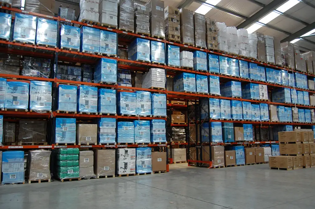 Almacén industrial con racks llenos de tarimas de inventario
