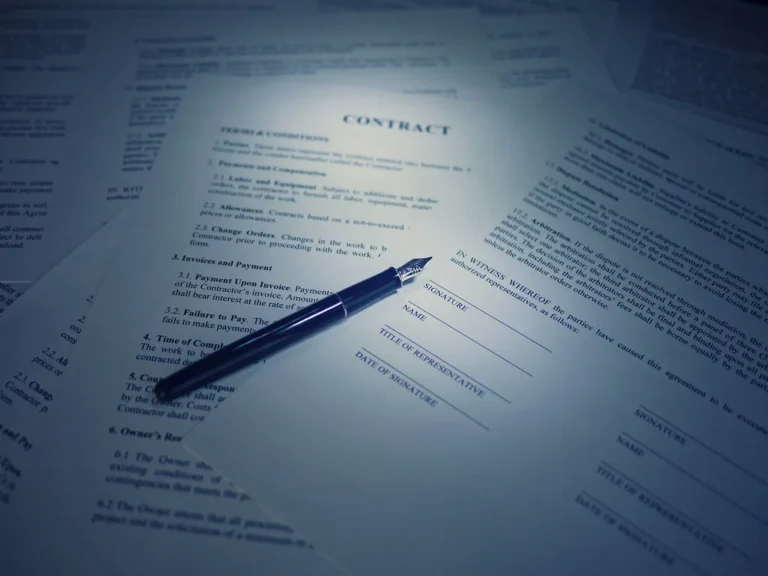 Contrato impreso con una pluma fuente encima, listo para firmarse
