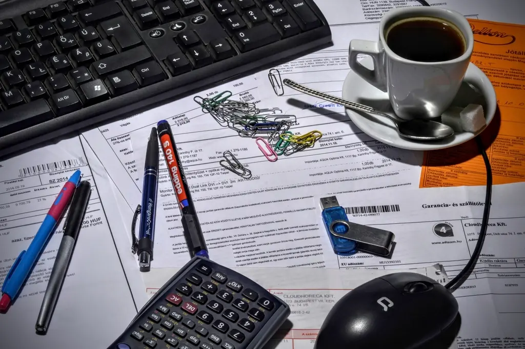 Facturas, calculadora y taza de café sobre un escritorio de contabilidad
