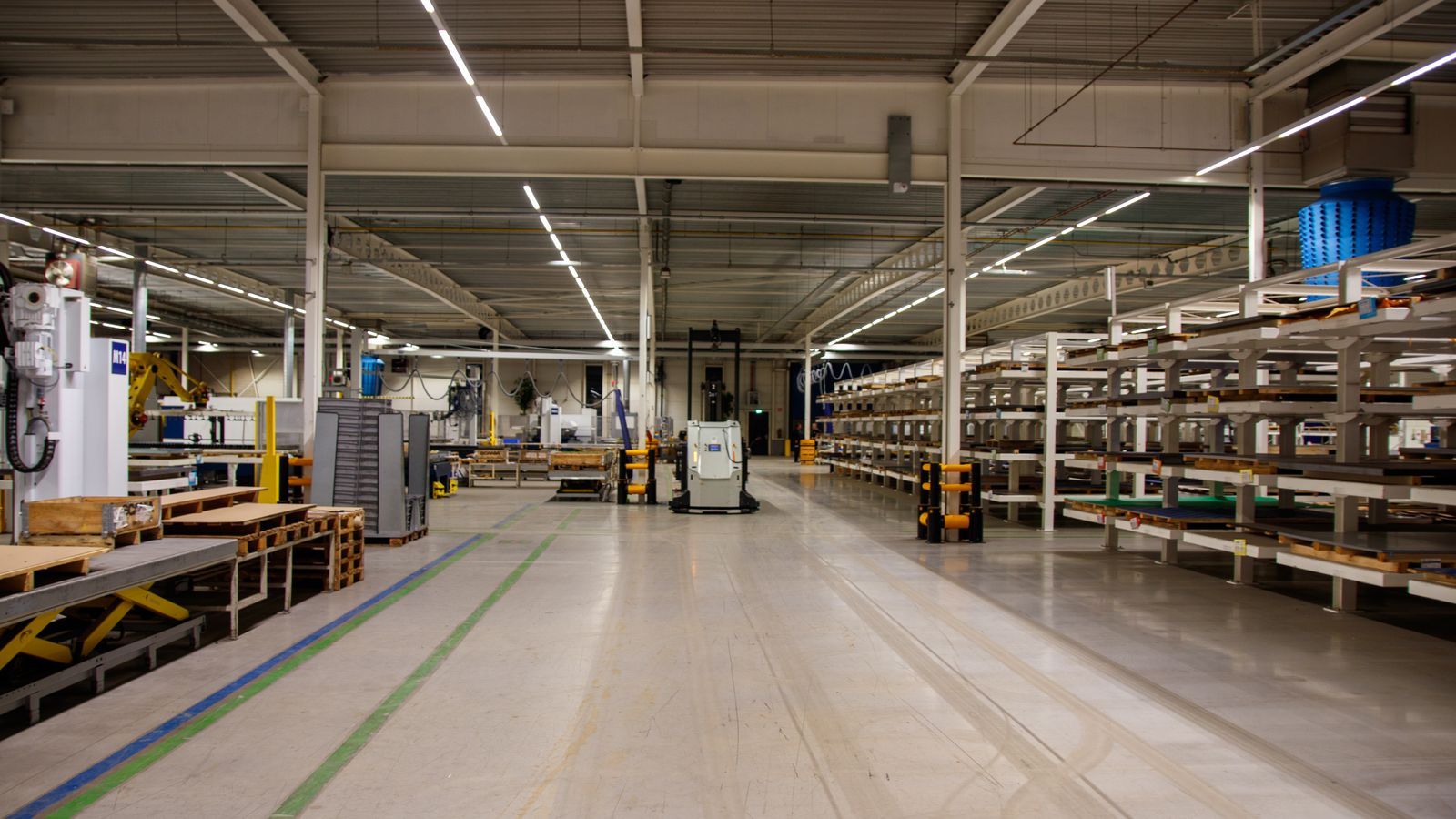 Interior de una nave industrial con maquinaria y racks de almacenamiento