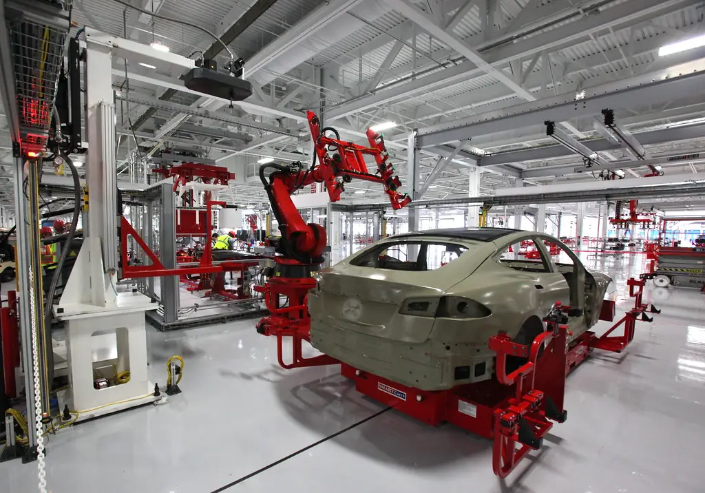 Robots industriales de soldadura trabajando sobre la carrocería de un automóvil