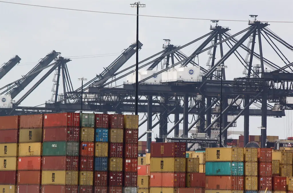 Grúas y contenedores apilados en una terminal portuaria